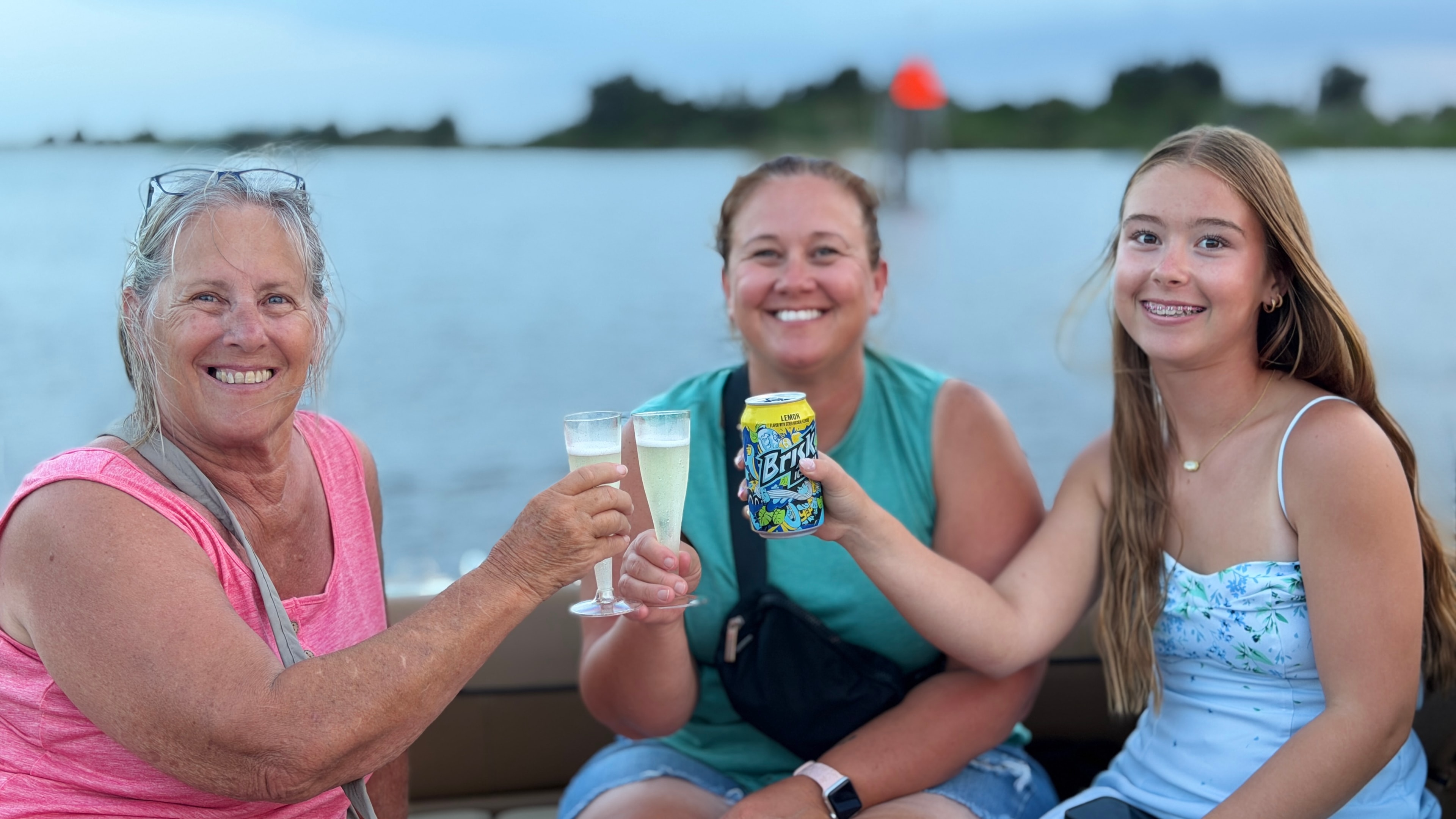 Three guests toasting champagne and drinks together on a sunset cruise on Daytona Beach's Intracoastal Waterway
